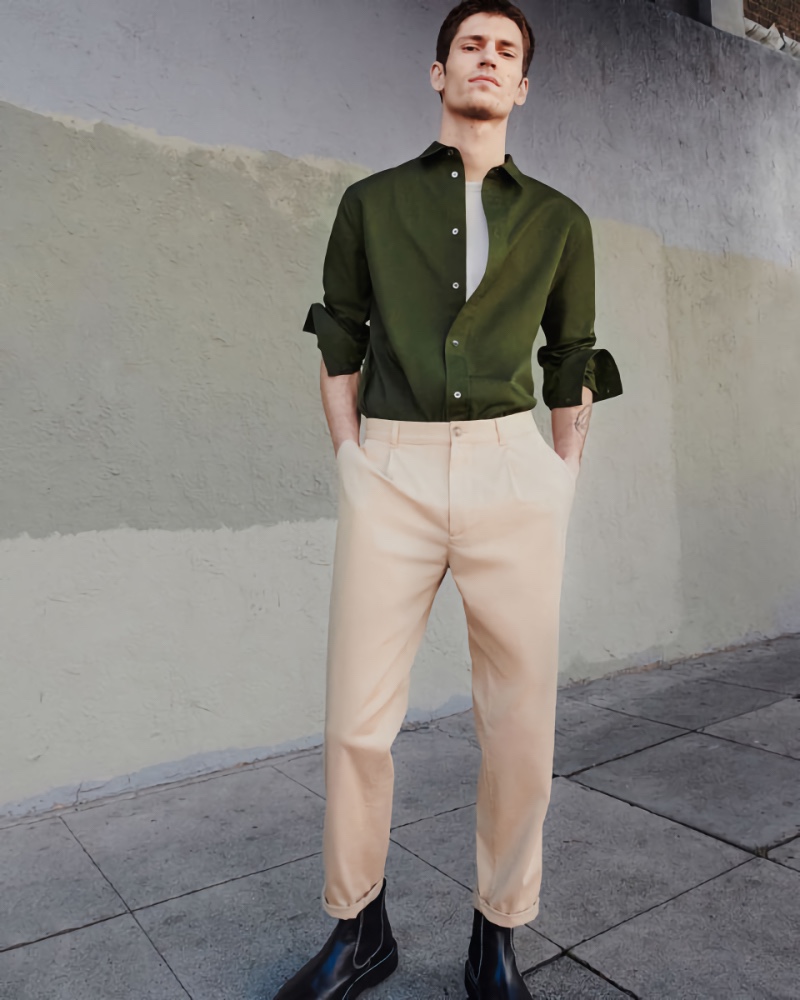 Model Justin Eric Martin wears a green shirt with trousers and leather boots from COS.