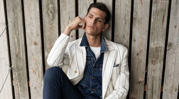 Pau Ramis dons a striped double-breasted blazer over a denim jean jacket for Eleventy Milano's spring-summer 2022 campaign.