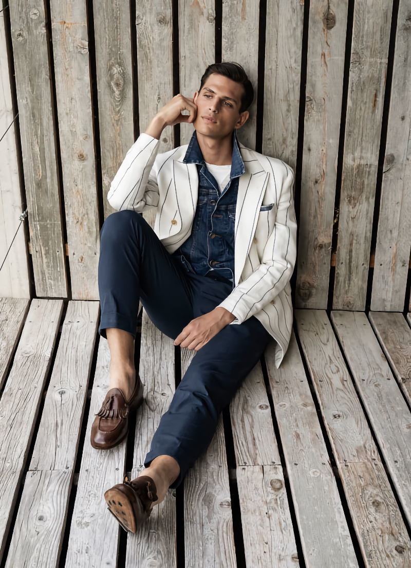 Pau Ramis dons a striped double-breasted blazer over a denim jean jacket for Eleventy Milano's spring-summer 2022 campaign.