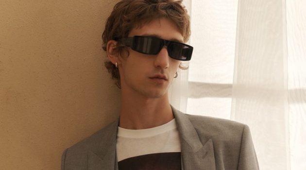 HUGO Sets Its Own Trendy Spring Statement Etienne de Testa dons a modern gray suit with a HUGO logo graphic tee.