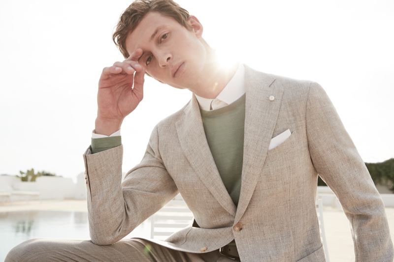 Alexis Maçon-Dauxerre dons a linen suit with a green sweater for Luigi Bianchi's spring-summer 2022 campaign.