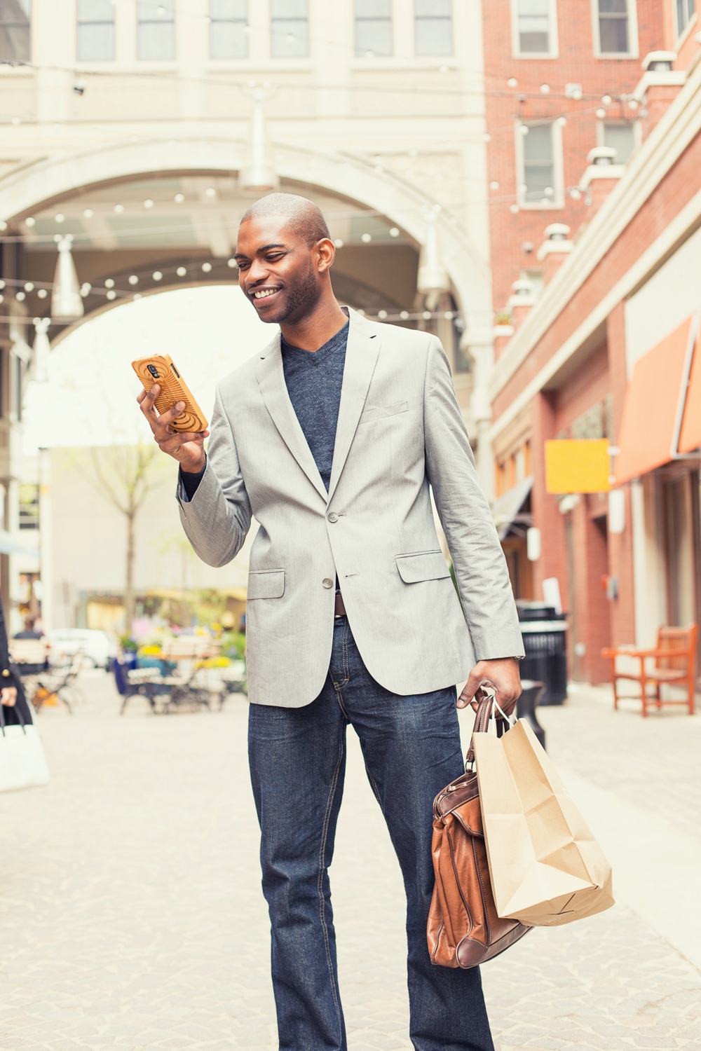 Man in Blazer on Phone Outside with Shopping Bags