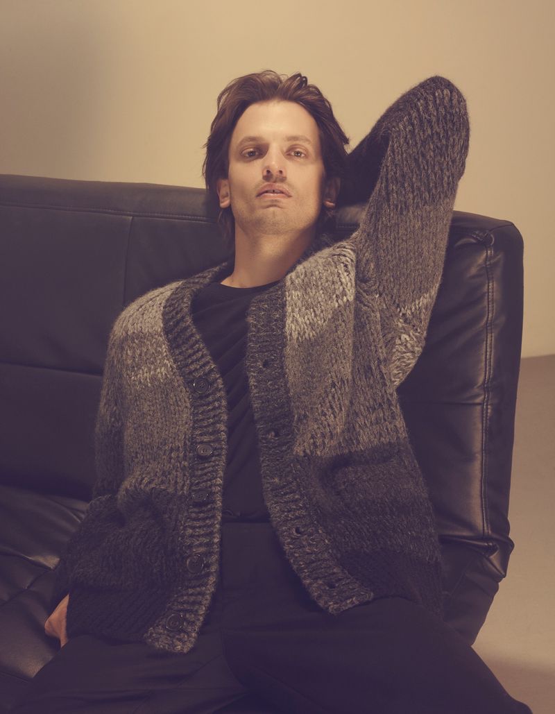 Model Eddie Klint wears a black and gray cardigan from Roberto Collina's fall-winter 2022 collection.
