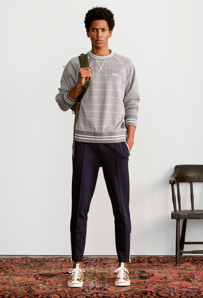 Model Rafael Mieses dons a Todd Snyder x Converse Jack Purcell crewneck sweatshirt in plaid.