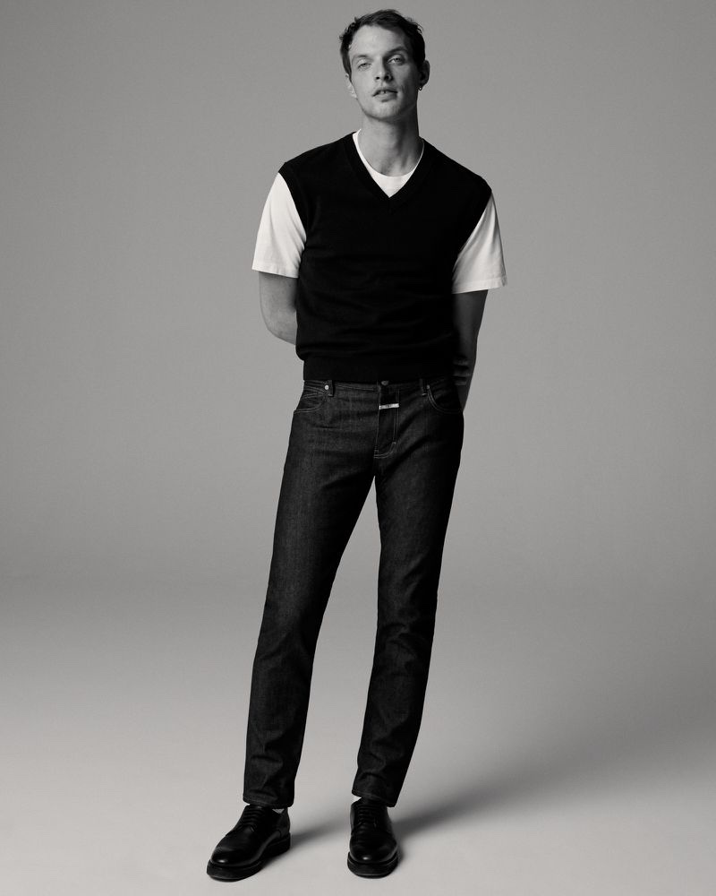 Donning a sweater vest with dark wash jeans, Rocky Harwood stars in Closed's spring-summer 2022 denim campaign.