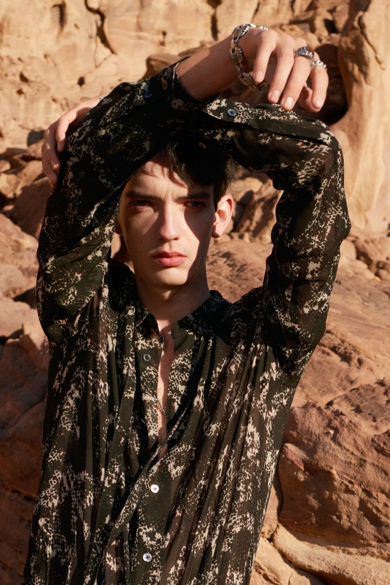 In front and center, Kodi Smit-McPhee sports a black abstract snake print shirt with a silver bracelet and rings for Zara Man's spring-summer 2022 Studio collection campaign.