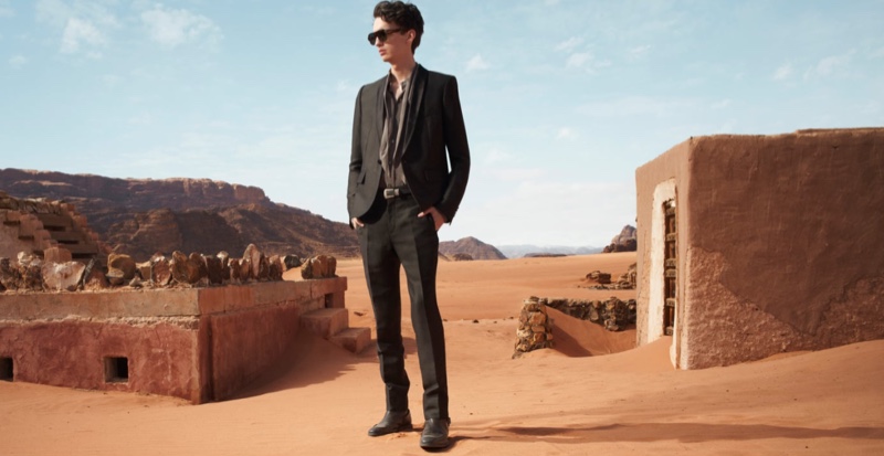 Dressed to impress, Kodi Smit-McPhee models a black tuxedo suit with a grey scarf collar silk shirt and western buckle leather belt for Zara Man's spring-summer 2022 Studio collection campaign.