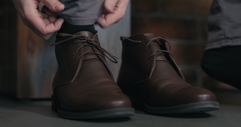 Man Putting On Mens Chukka Boots Brown