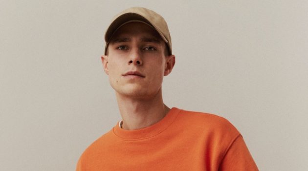 Mango Stands Behind a Bright Orange Note Taking up the spotlight for spring, Jeff Hinton sports an orange sweatshirt by Mango Man.