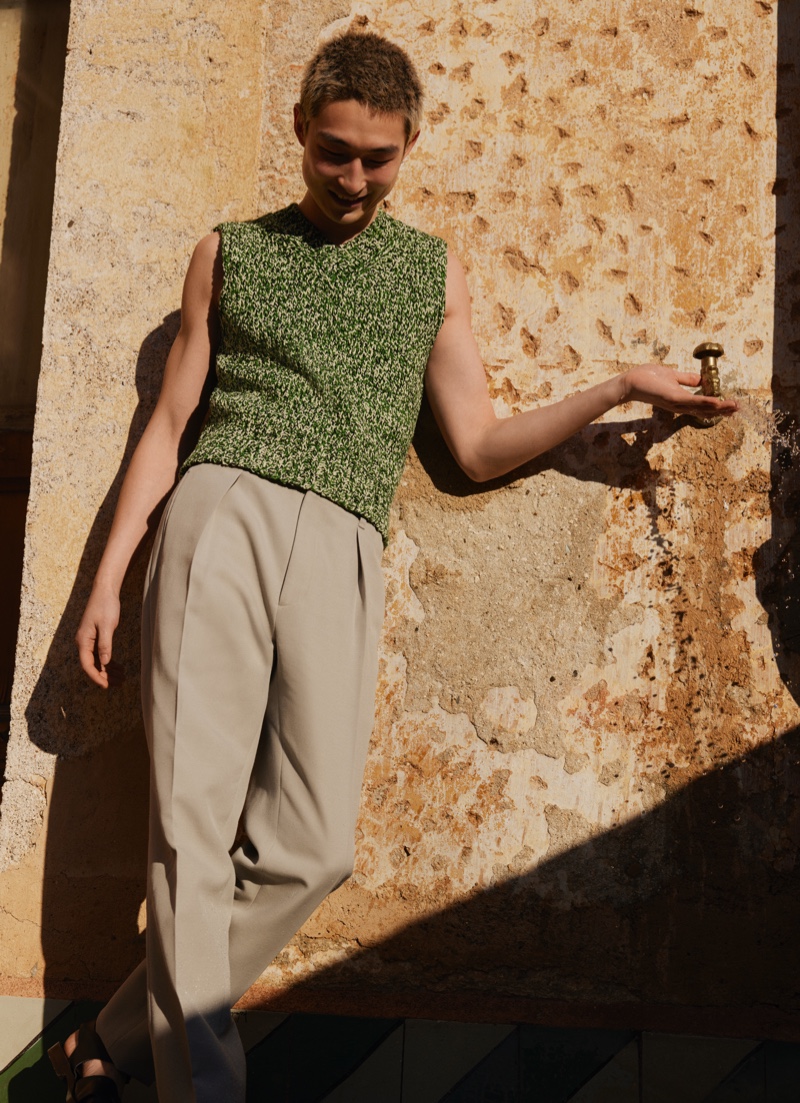 All smiles, Sang Woo Kim wears a Maison Margiela sweater vest for Mytheresa's men's campaign.