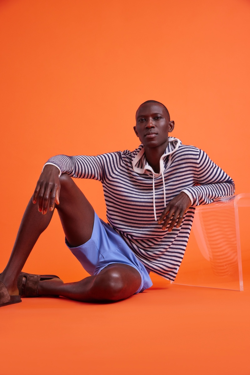Armando Cabral models swim shorts with a striped hooded sweater by Onia.