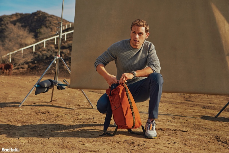 Connecting with Men's Health, Sam Heughan sports a Billy Reid thermal shirt, Vuori performance pants, Sketcher sneakers, an Epperson backpack, and a Shinola watch.