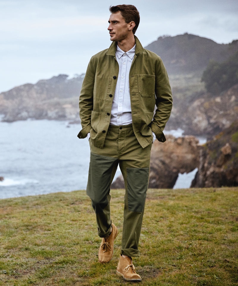 Making a monochrome statement in surplus olive, Clément Chabernaud wears a Japanese patched chore coat and pants with a selvedge oxford shirt by Todd Snyder.