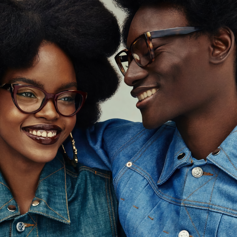 All smiles, Mari Taylor wears Warby Parker's Camila glasses in Oxblood with Striped Elm while Youssouf Bamba models the Cumberland glasses in Burnt Umber Tortoise with Marcona Tortoise.