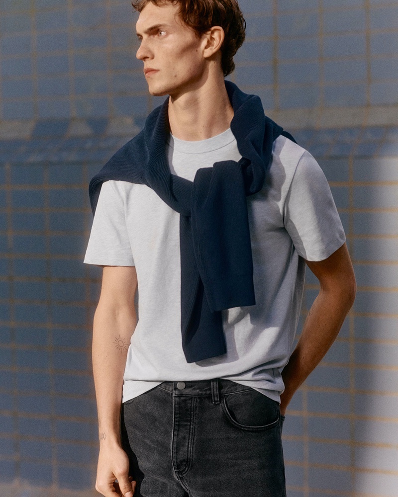 A casual but chic vision, Luc Defont-Saviard sports a t-shirt with jeans and a sweater tied around his neck.