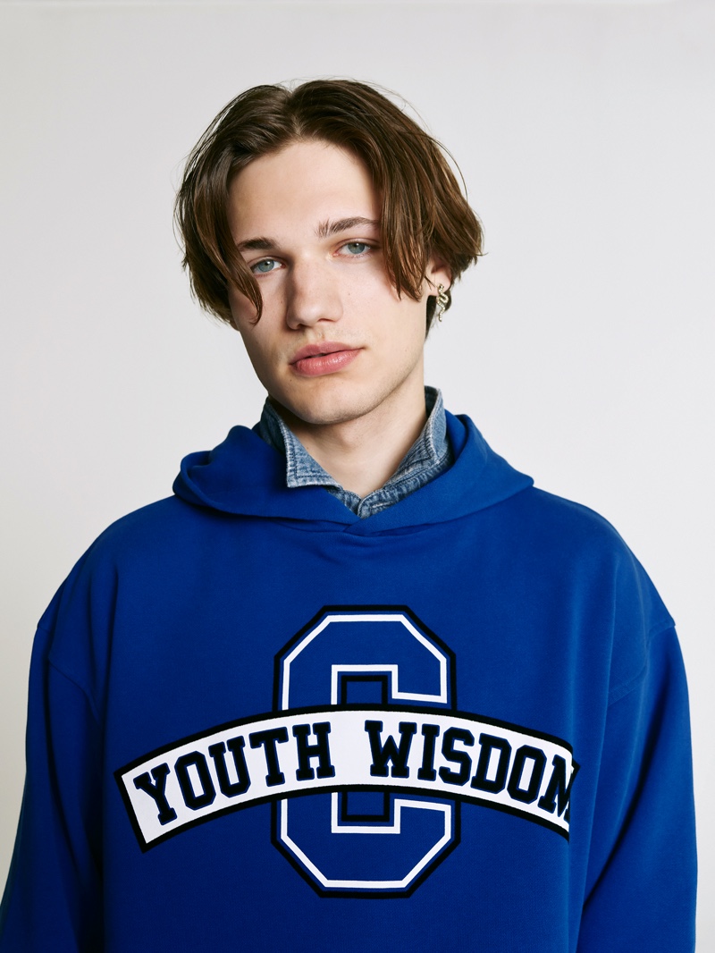 Valentin Delatron goes casual in a blue sweatshirt for the Closed x Philouze capsule collection campaign. 