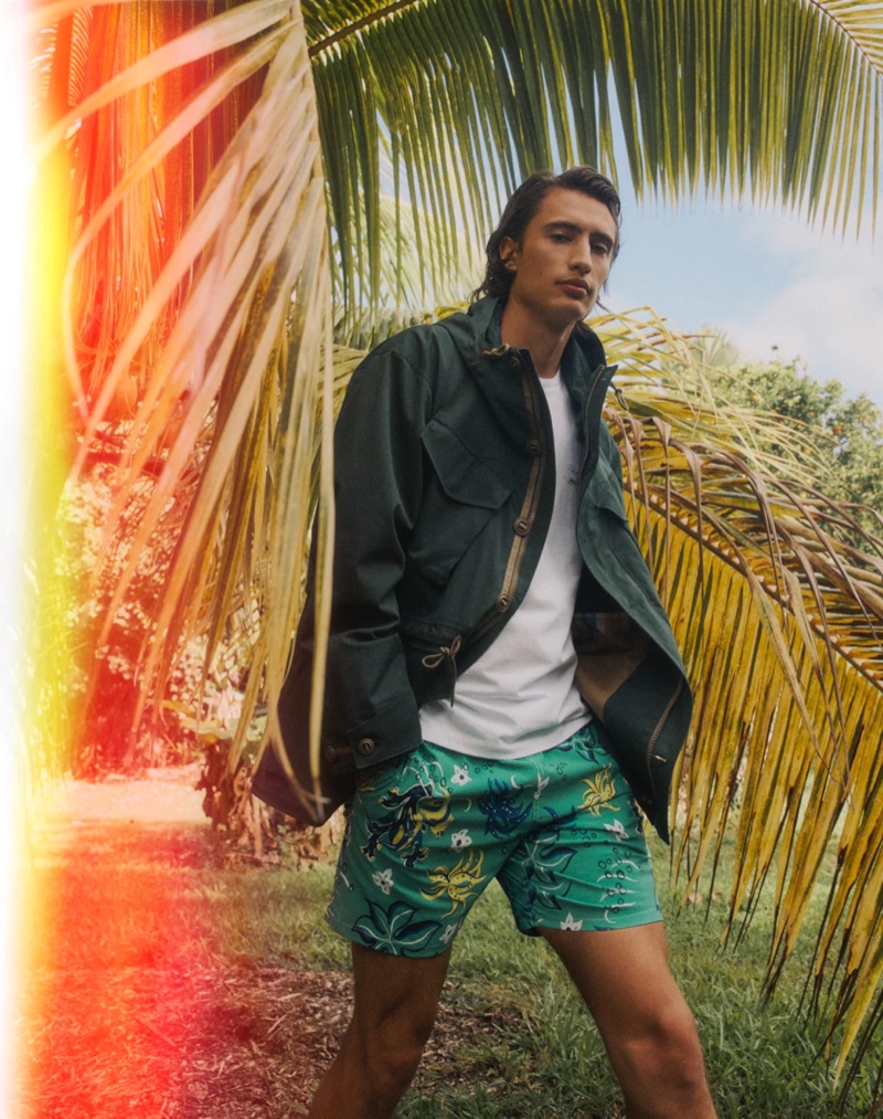 Model James Turlington wears a J.Crew cotton-nylon survey parka with a sailing map graphic t-shirt, and 6" stretch swim trunks in a "Under the Sea" green.