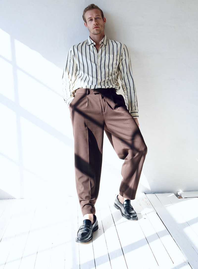 Kevin wears shirt Sandro, trousers Acne Studios, and shoes Hudson London.