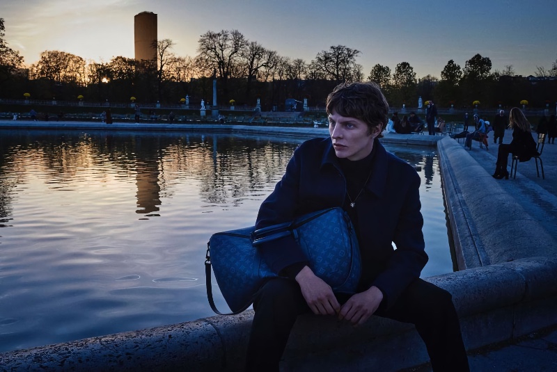 German model Tim Schuhmacher poses with one of Louis Vuitton's leather keepalls for the brand's 2022 campaign.