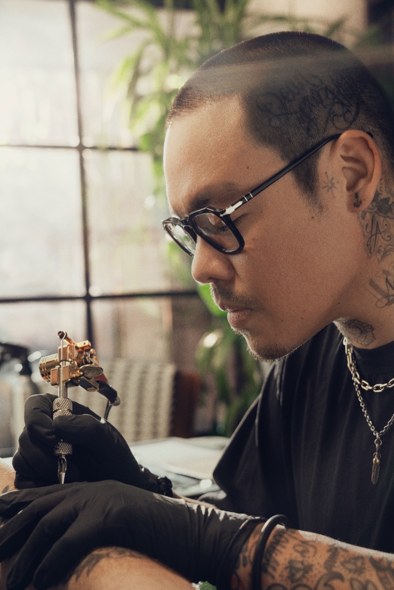 Working on a tattoo, Dr. Woo wears glasses from Persol for the brand's new "The Drive, Within" campaign.