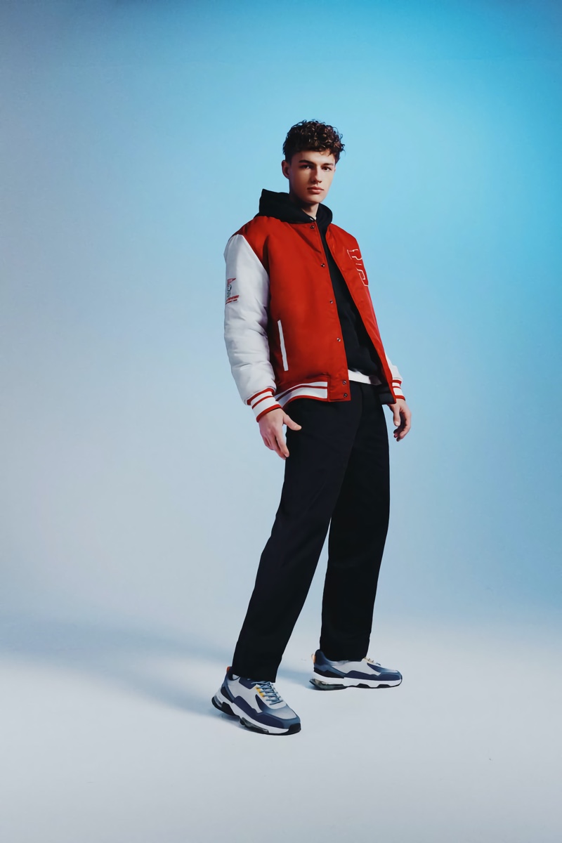 Model Ondrej Mokoš sports a red varsity jacket from Pull & Bear.