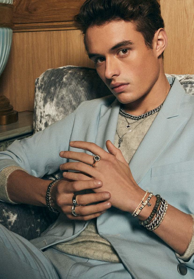 Model Duke Maxwell showcases beaded bracelets, a chain necklace, rings, and more from Sydney Evan.