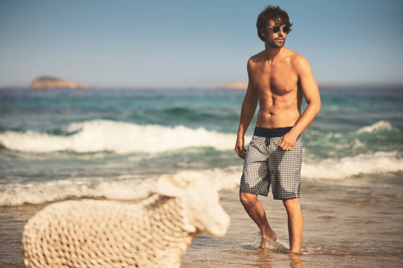 Model James Crabtree hits the beach in boardshorts from the Vilebrequin x The Woolmark Company collection.