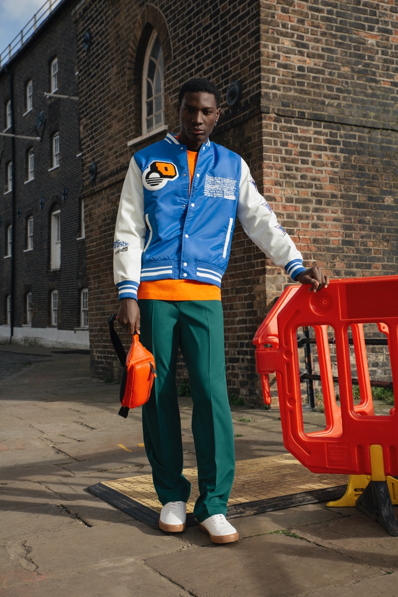 Charles wears t-shirt Heron Preston, shoes Birkenstock, pants, bag, and varsity jacket Zara.