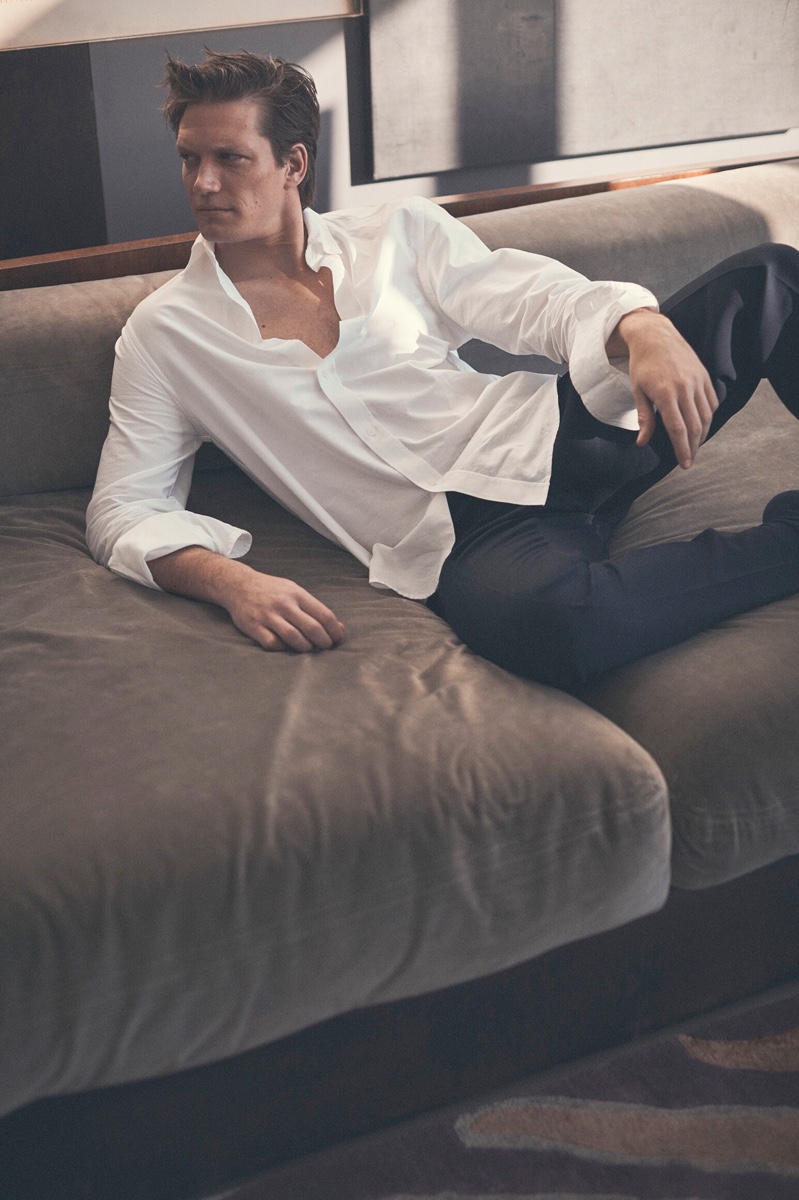 Relaxing, Florian Van Bael showcases smart style in a Kenzo oxford shirt with Etro trousers for Luisaviaroma.