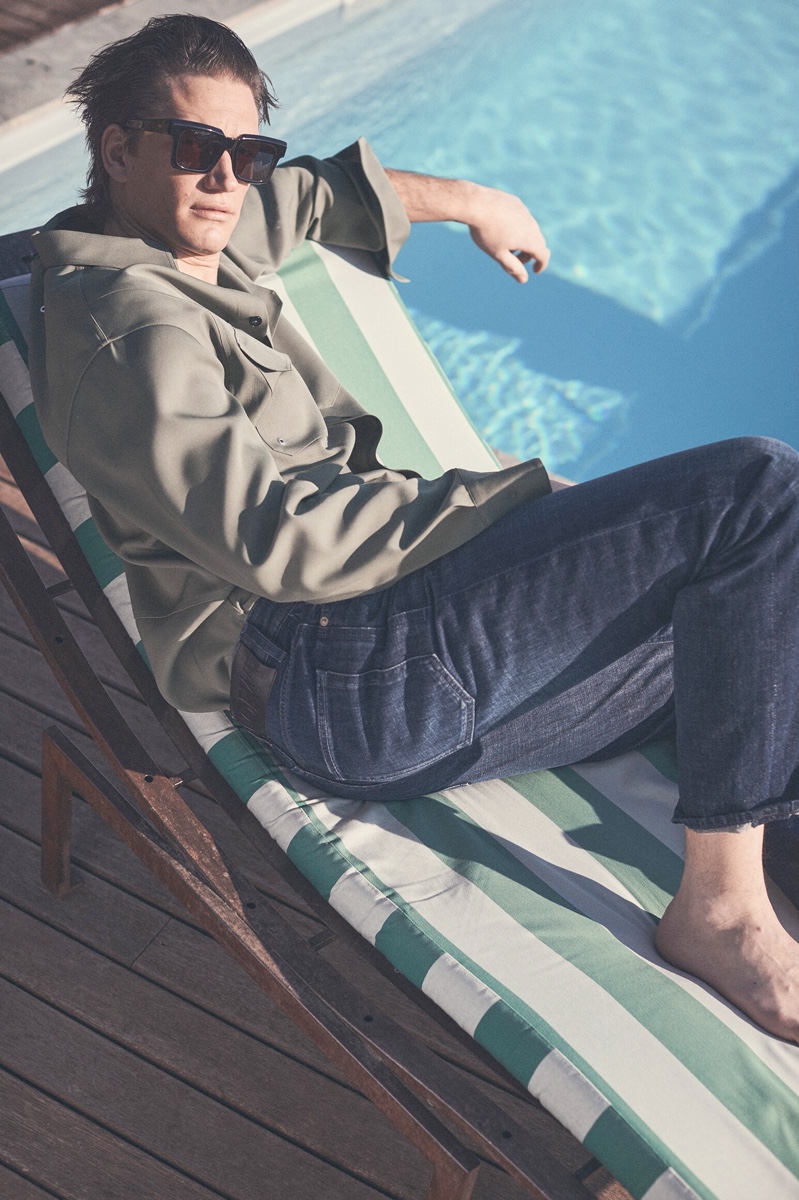 Relaxing poolside, Florian Van Bael sports a Jil Sander shirt with Loewe jeans and Retrosuperfuture sunglasses.