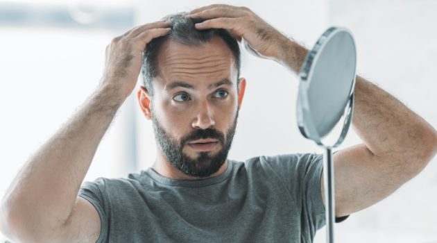 Common Myths & Misconceptions About Hair Transplants Man with Thinning Hair Mirror