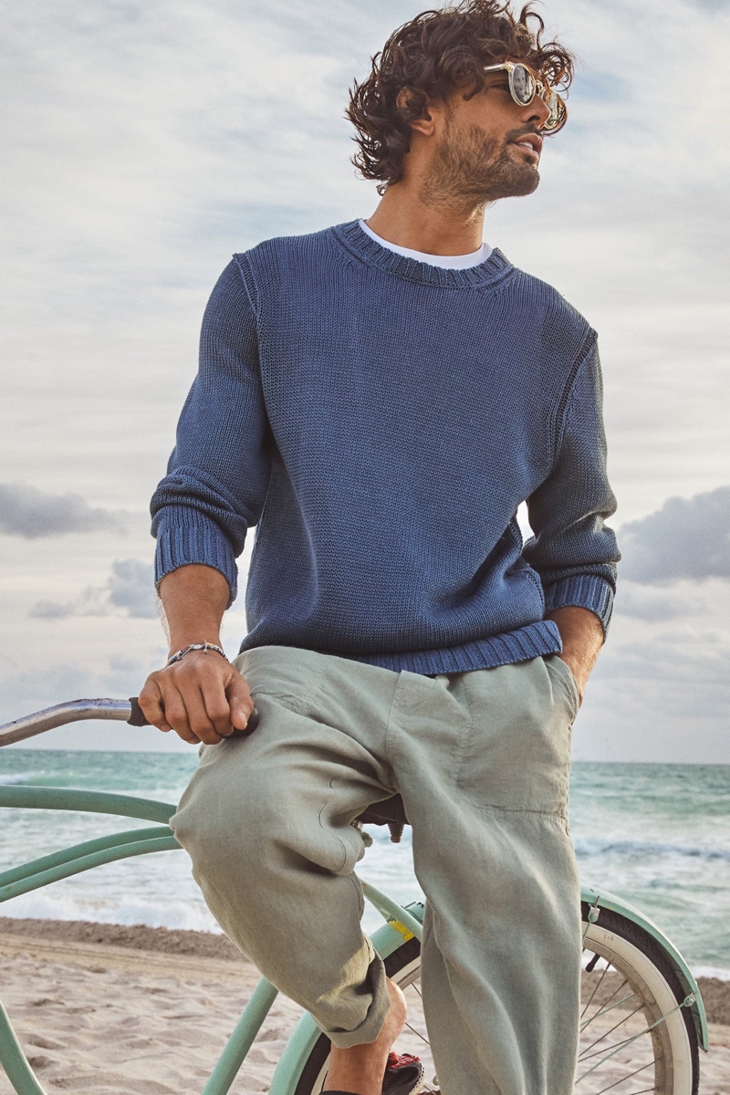Taking to the beach, Marlon Teixeira sports Todd Snyder's  Italian linen Beach pant and crewneck sweater.