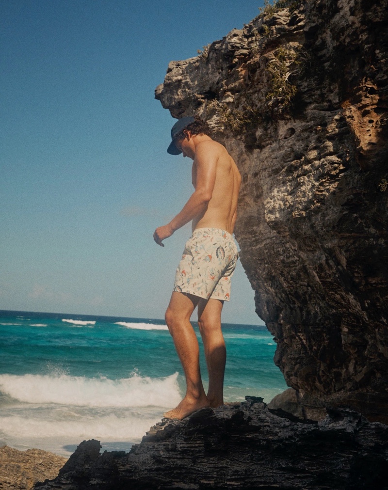 Canadian model Simon Nessman wears a J.Crew garment-dyed twill baseball cap with 8" stretch swim trunks in Daylight Beach Ivory.