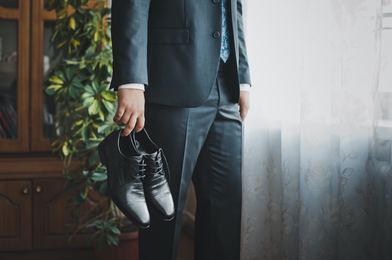 Man Suit Holding Dress Shoes