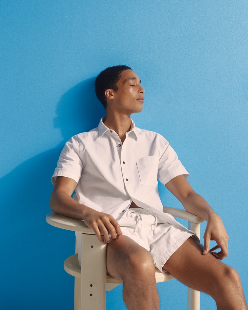 Luke Cousins is a refined vision in white. He wears Onia's summer denim pull-on short and shirt.