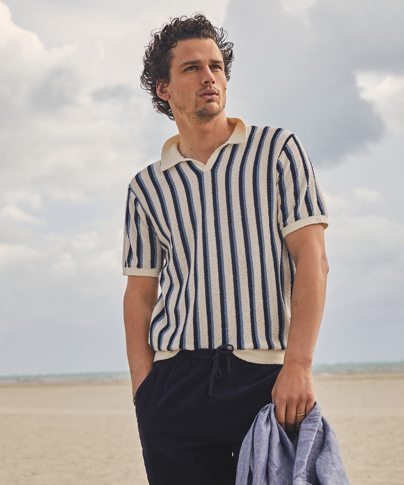 Simon Nessman takes to the beach in a cotton boucle vertical stripe sweater polo in ivory from Todd Snyder.