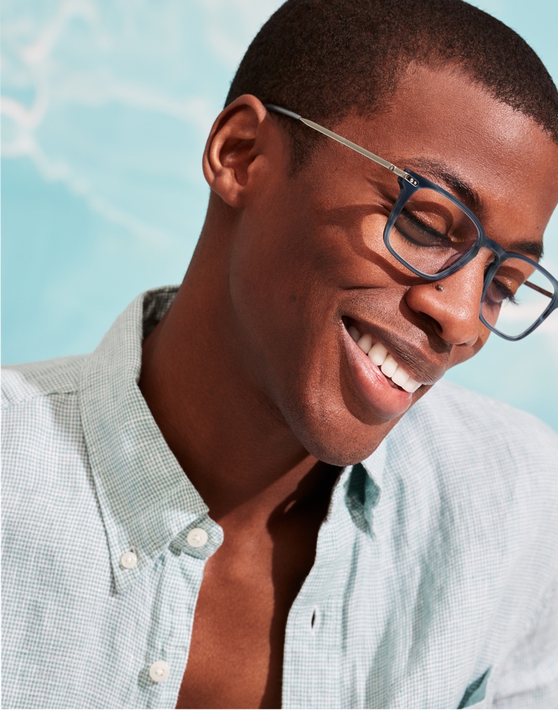 All smiles, Magor Meng wears Warby Parker's Raul glasses in Striped Pacific with Polished Silver.