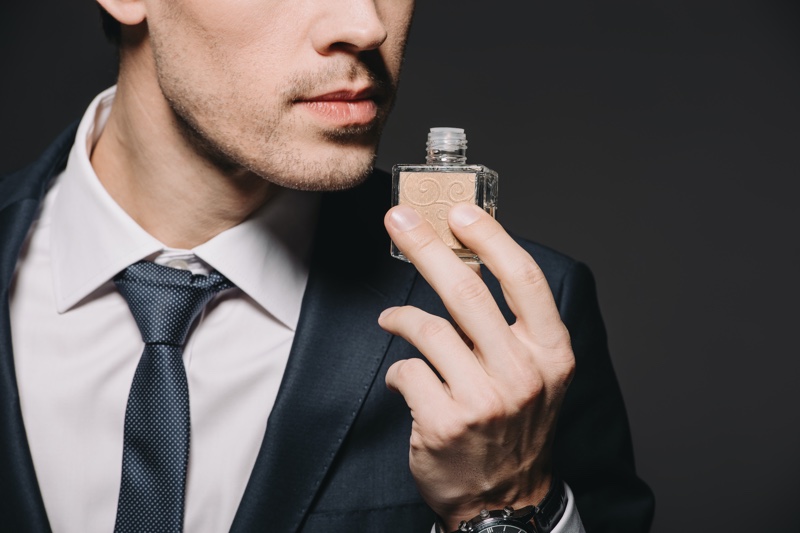 Closeup Man Suit Holding Cologne