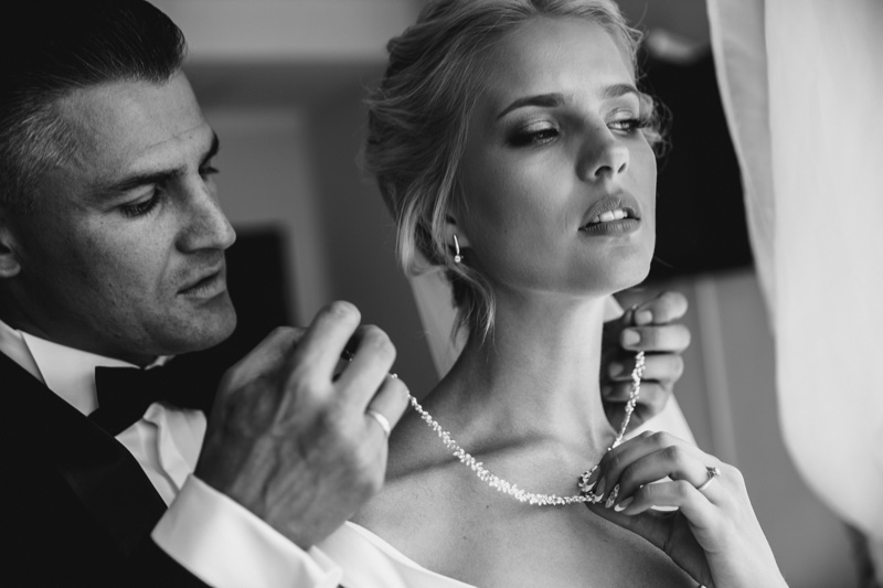 Groom Putting Diamond Necklace on Bride