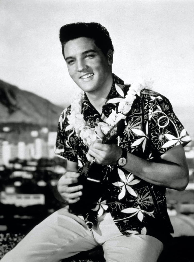 Elvis Presley in a Hawaiian shirt with large white floral print, photographed for the 1961 film Blue Hawaii