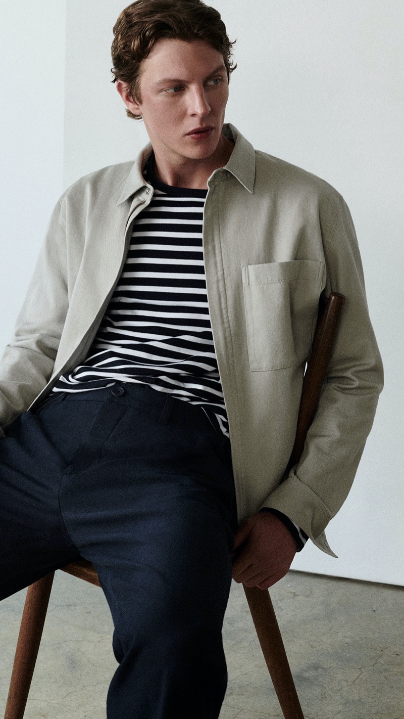 Sporting COS, German model Tim Schuhmacher dons a striped top with relaxed-fit, wide-leg pants, and a relaxed-fit zip-up shirt.