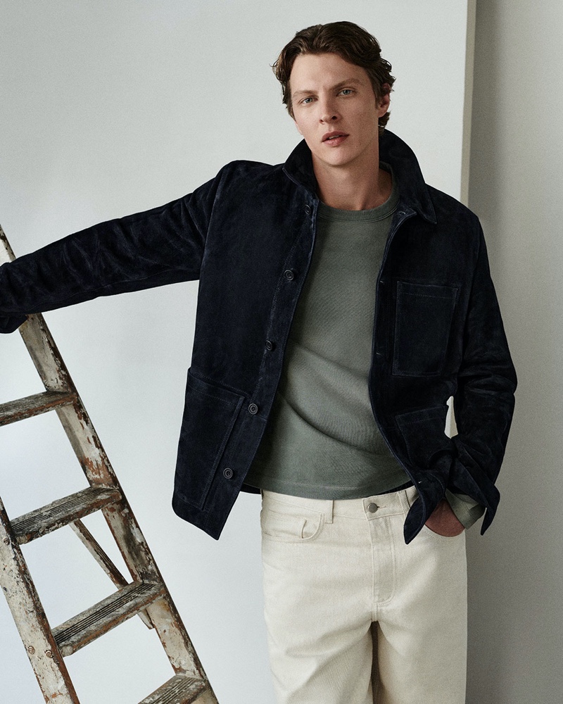 Embracing COS's fall style, Tim Schuhmacher models a suede jacket with a heavyweight sweater and light-colored jeans.