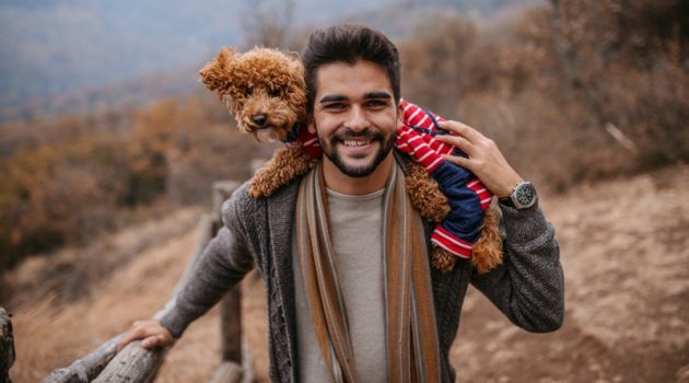 Man Smiling with Dog Wearing Clothes