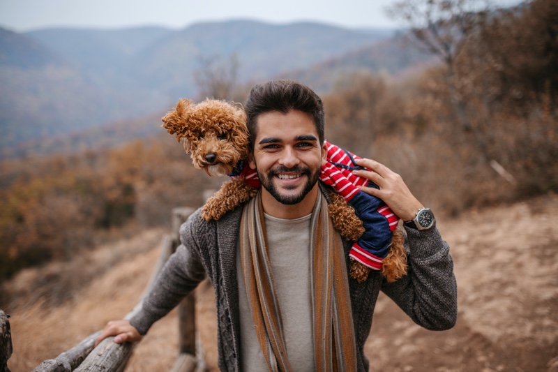 Man Smiling with Dog Wearing Clothes