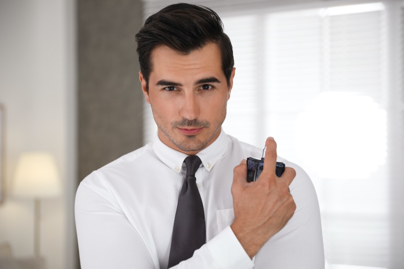Attractive Man Holding Cologne Bottle