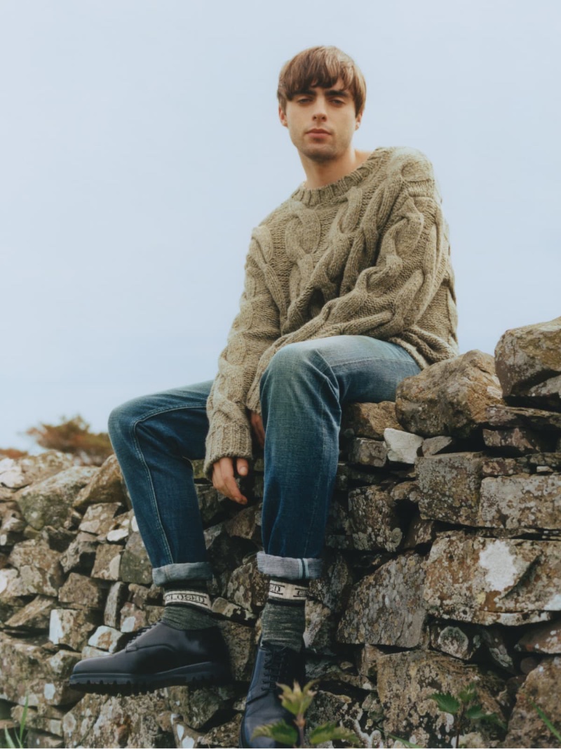 Model Lennon Gallagher wears a cable-knit sweater with jeans for Closed's winter 2022 campaign. 