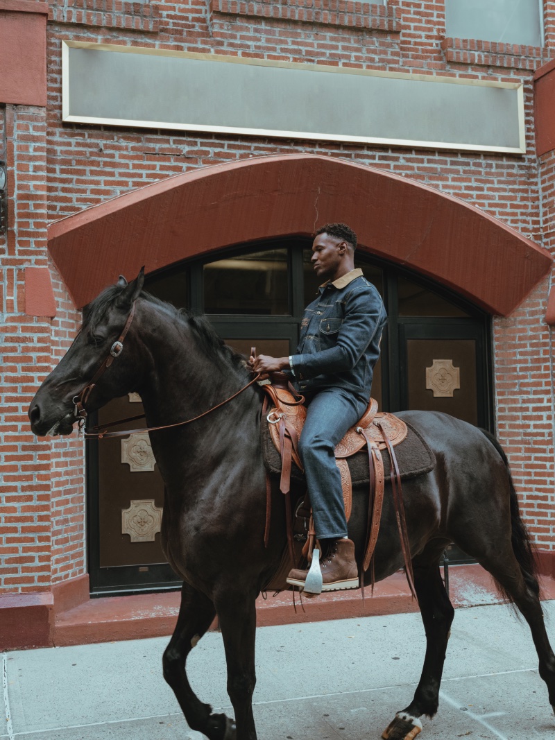 Riding a horse, Christopher Gary Lawson sports a denim look from the new Lee x The Brooklyn Circus collection.