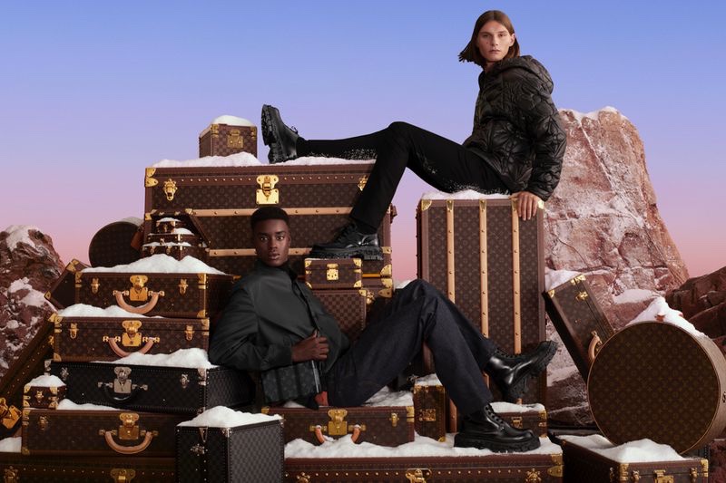 Babacar N'Doye and Teo Fortin pose on Louis Vuitton luggage trunks for the brand's holiday 2022 campaign.