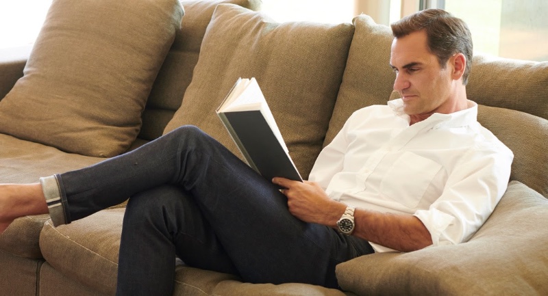 Relaxing on the couch, Roger Federer sports a UNIQLO oxford shirt with selvedge stretch slim-fit jeans.