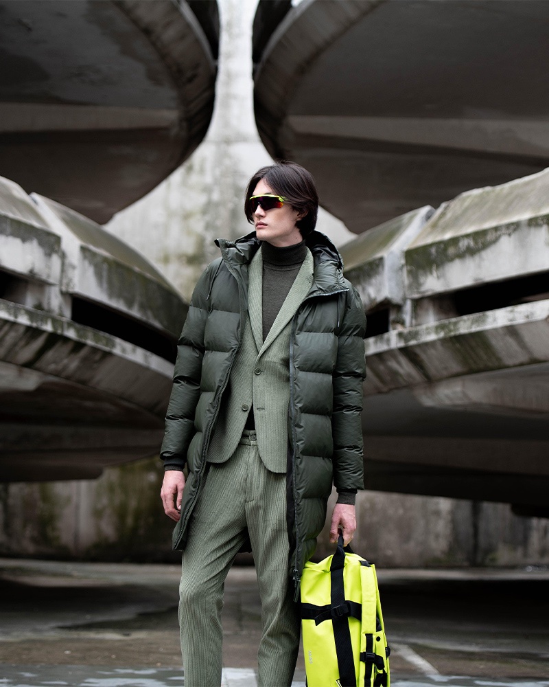 Sporting a long puffer jacket by Rains, Joseph Norris also wears a Drykorn suit.